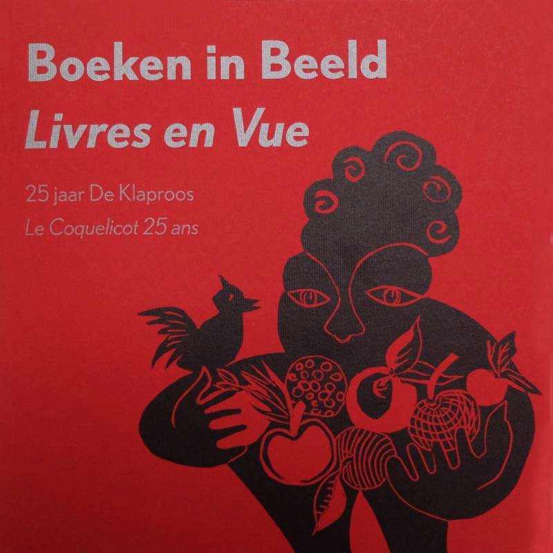 Rode boekkaft bedrukt met zilveren letters en tekening van een vrouw met fruit en een vogel in zwart gedrukt. De titel 'Boeken in Beeld / Livres en Vue'